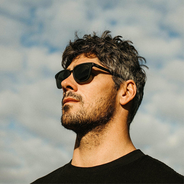 Jay Davies wearing black sunglasses looking into the sky