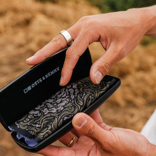 Artist Kentaro Yoshida holding sunglasses case and enamel flower pin
